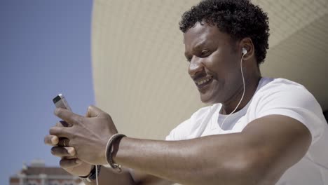 Smiling-African-American-man-listening-music-with-earphones